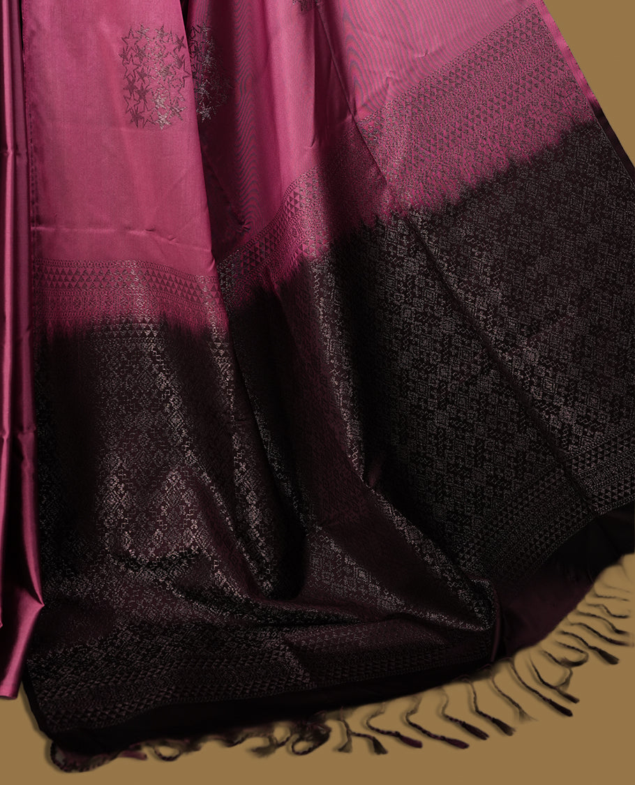 Dark mauve colour semi soft silk saree adorned with delicate woven floral motifs on the body, complemented by a rich contrast deep chocolate colour woven pallu with intricate detailing and tassel accents. Comes with a matching blouse piece