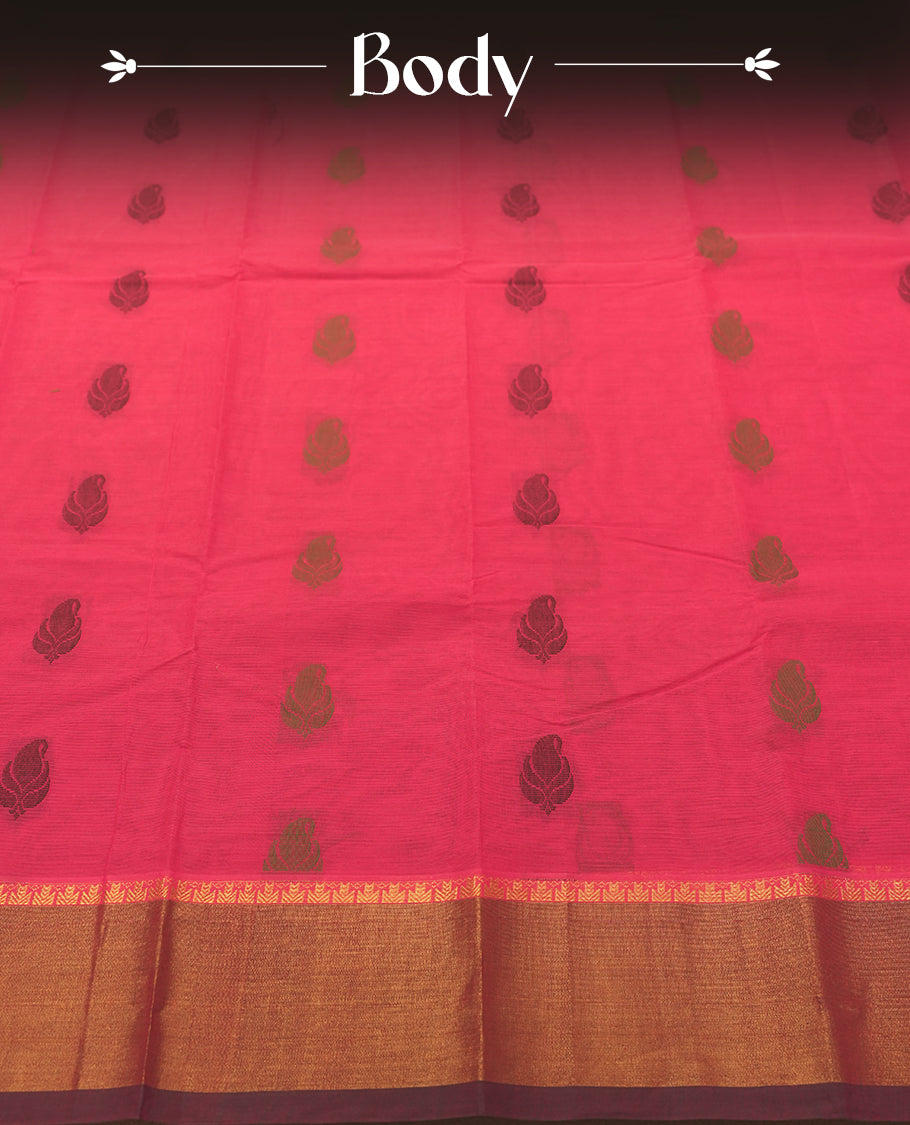 Rani Pink colour Silk Cotton Saree with Antique Copper Zari Border and Micro Geometric Edge, Body adorned with Subtle Leaf Buttas, Floral Jacquard Pallu, and a Coordinated Rani Pink Blouse with Matching Zari Border