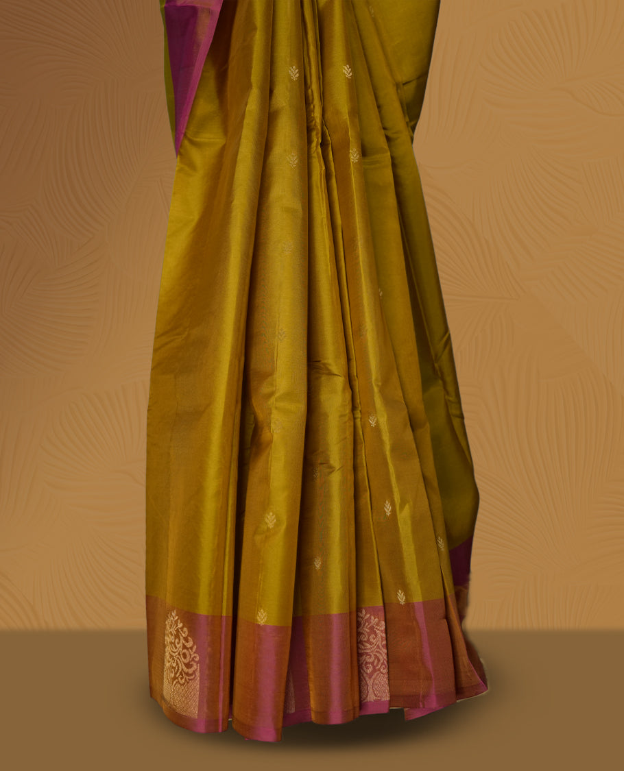Mustard yellow colour soft silk saree highlighted with a rich contrast pink border adorned with elegant zari motifs & Paired with a matching blouse.