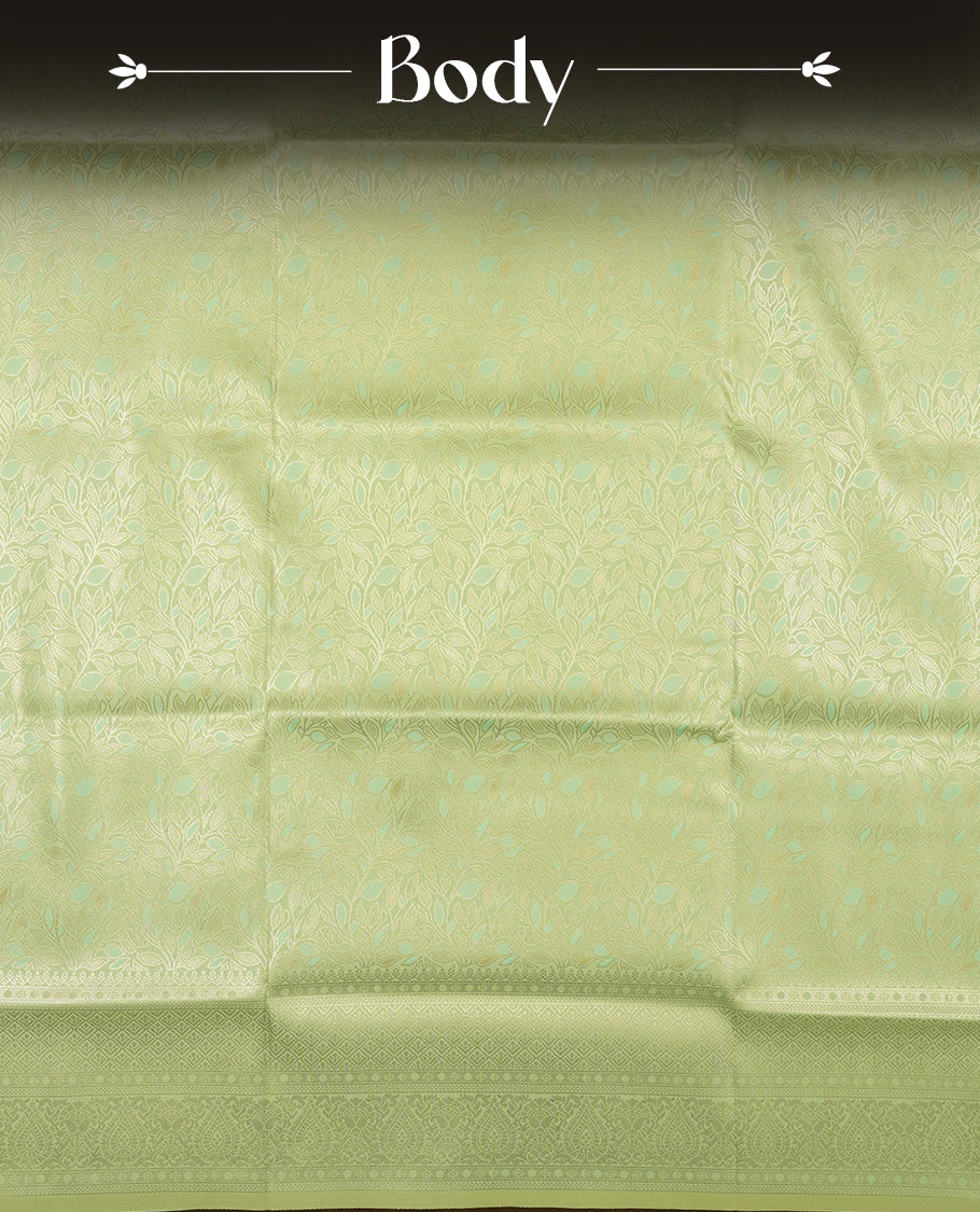 Light Green colour semi soft silk saree featuring an all-over woven leaf pattern in gold colour, finished with a matching border adorned with detailed paisley and floral motifs, and a matching blouse piece.