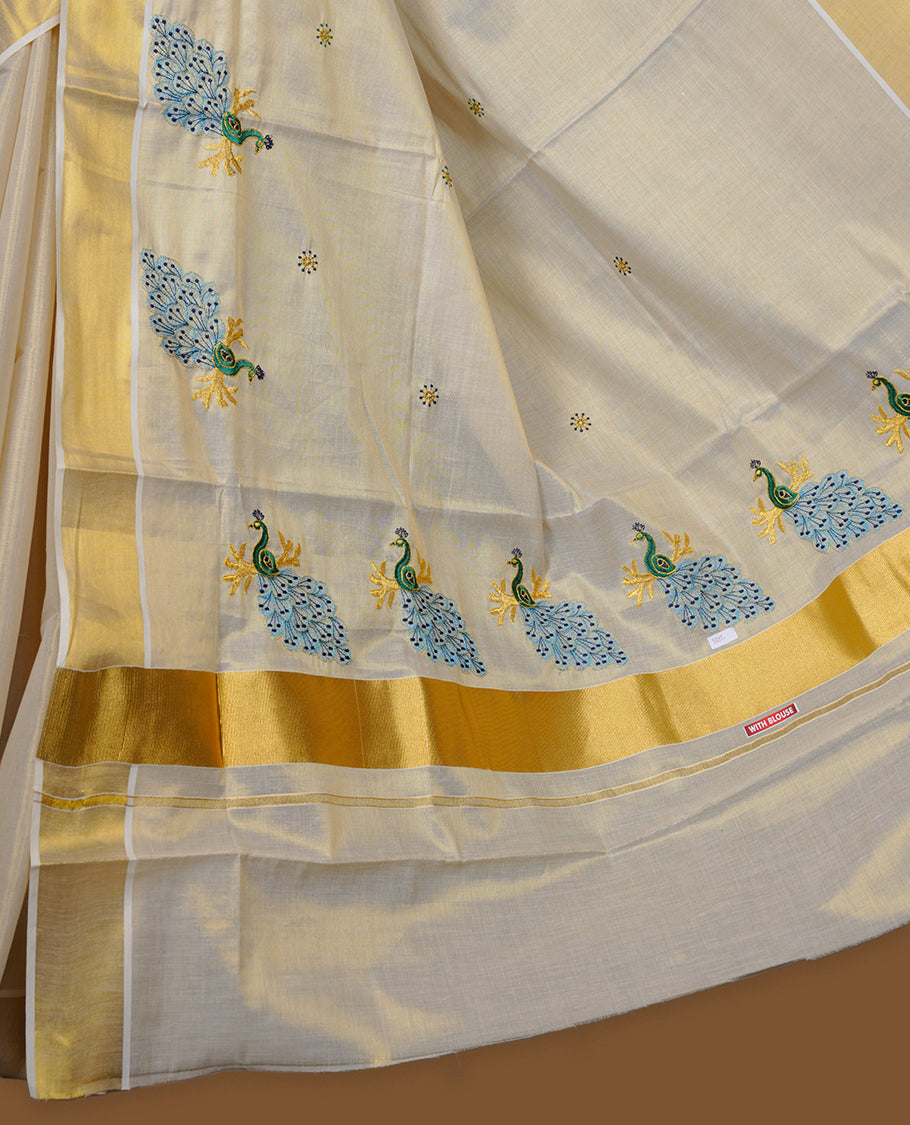 Off-white Kerala saree featuring a classic gold kasavu border, highlighted with graceful blue peacock motifs across the body and pallu, and paired with a matching blouse.