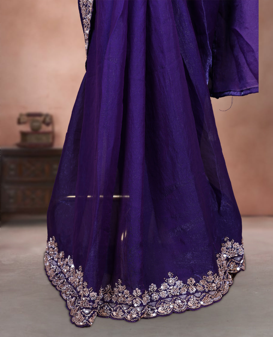 Elegant deep purple colour ready to wear saree adorned with rich gold bead embroidery along the border and pallu, paired with a heavily embellished matching blouse for a grand festive look.