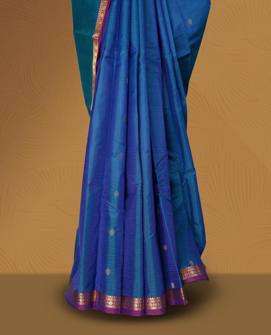 Blue colour soft silk saree adorned with delicate zari buttas, complemented by a rich contrast purple border with intricate golden zari work & Paired with a matching blouse.