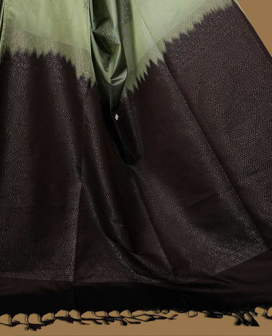 Pastel green colour semi soft silk saree, adorned with subtle self woven motifs on the body & The design is elevated with an elegant zari border and dark chocolate colour pallu, paired with a matching blouse.