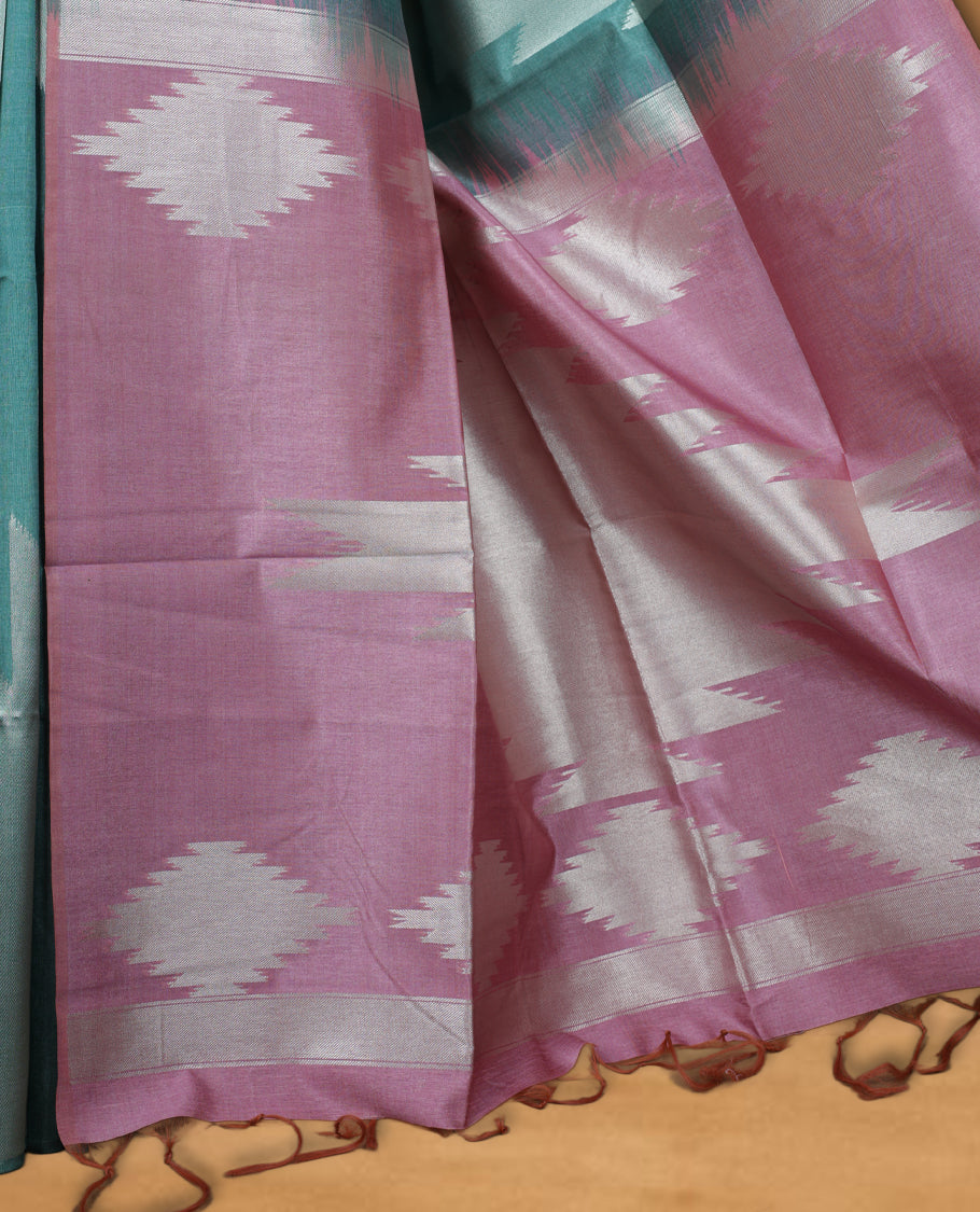 Green and silver dual tone colour semi tussar saree featuring woven abstract geometric motifs on the body, complemented by a ikat inspired patterned pallu, paired with a matching blouse.