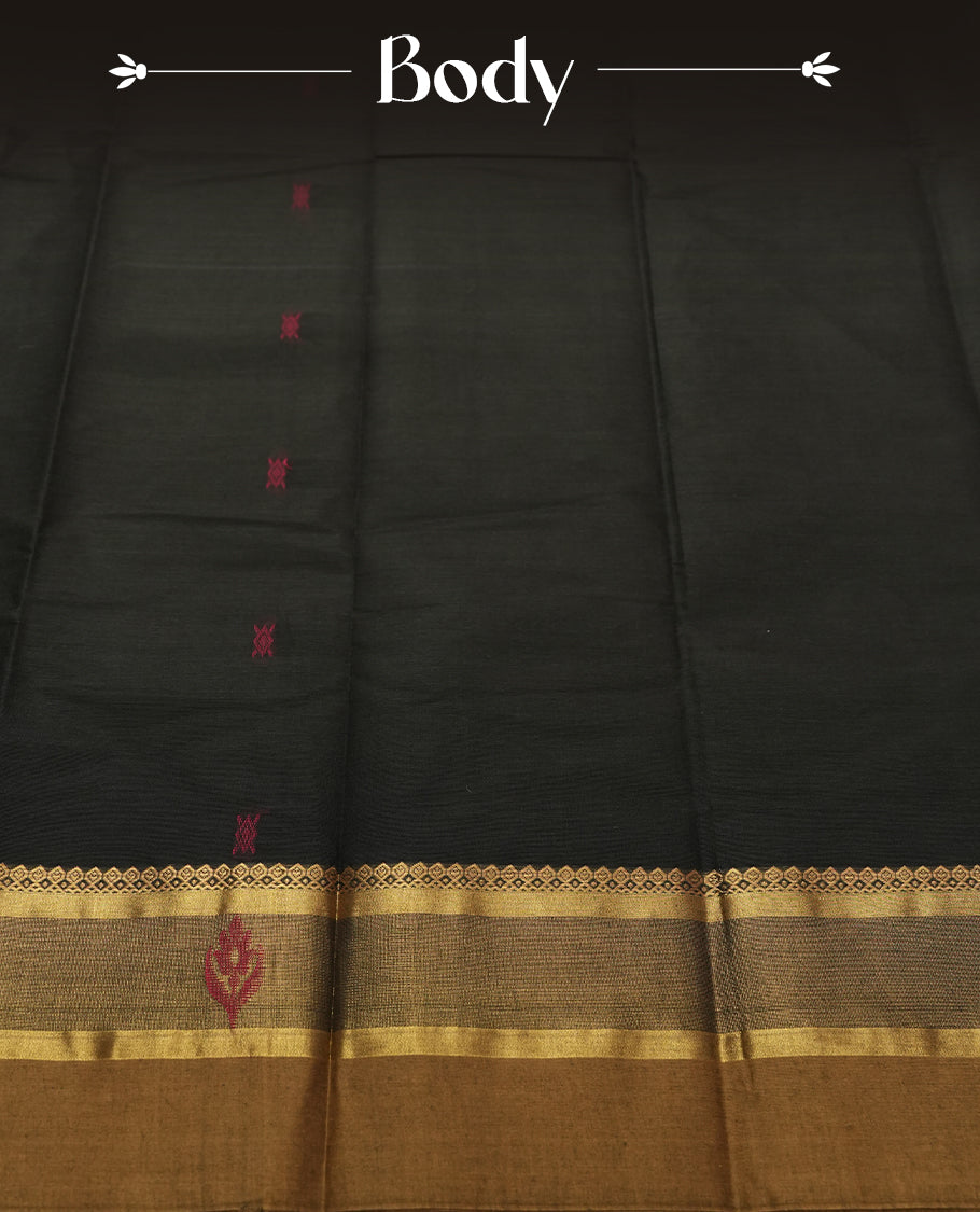 Black Colour silk cotton saree with scattered pink and orange buttas, gold and bronze temple border with pink floral band, gold zari pallu with leaf patterns, black blouse with bronze border.