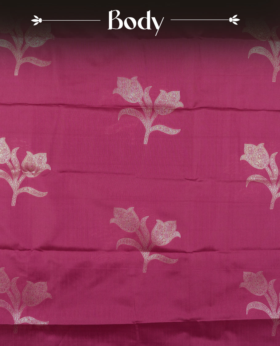 Burgundy colour semi silk saree adorned with elegant floral motifs on the body, complemented by a shimmering golden zari-woven pallu and border, and paired with a matching blouse