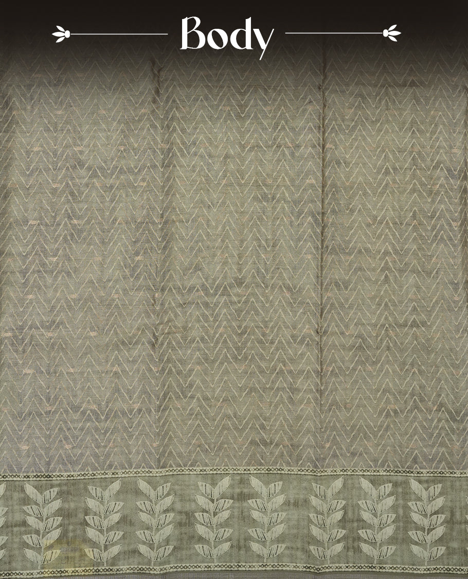 Olive sage colour semi tussar saree adorned with Cream Zigzag printed pattern across the body and Leaf pattern on contrast olive sage colour border, paired with a matching blouse.