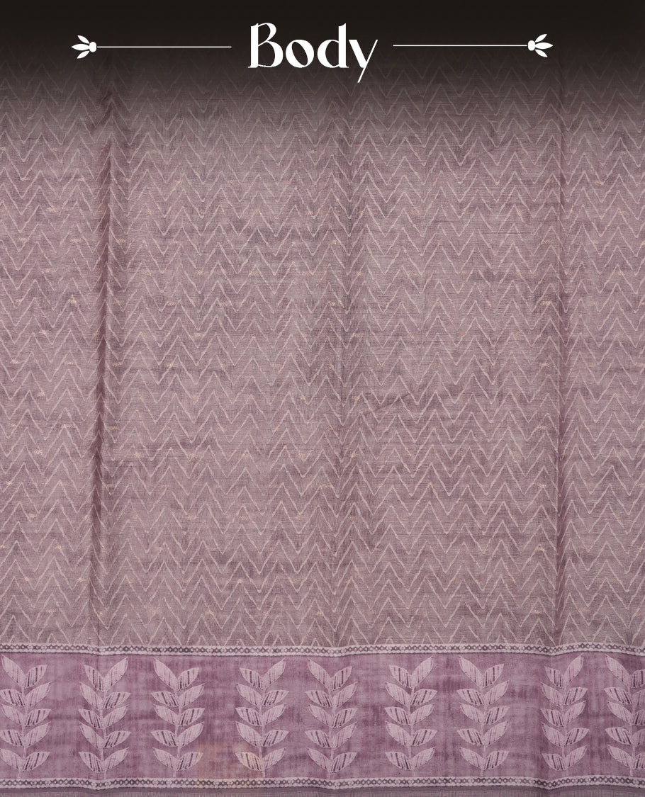 Pink copper colour semi tussar saree adorned with Cream Zigzag printed pattern across the body and Leaf pattern on contrast Dusty pink colour border, paired with a matching blouse.