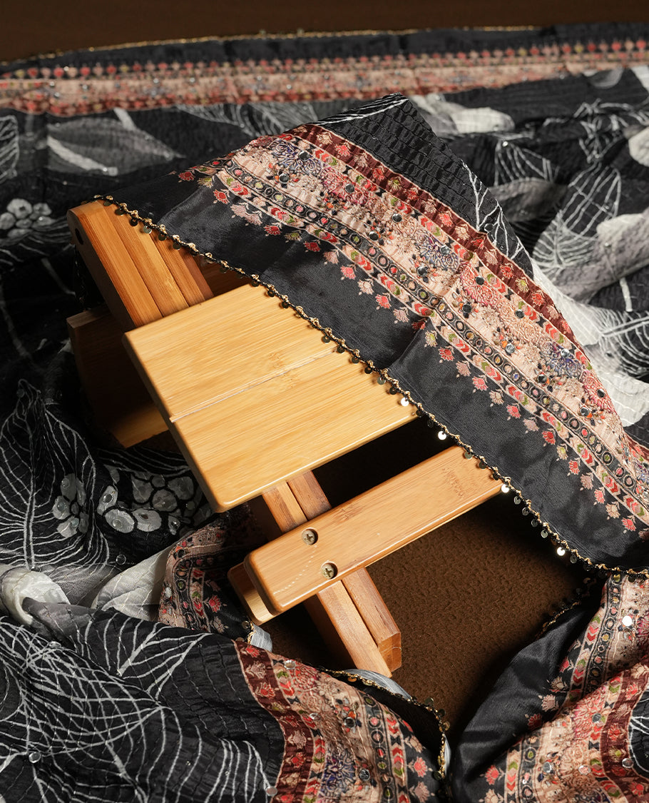 Off white colour churidhar material featuring Mirror and thread embroidery, foral print pattern on the contrast black colour front panel, floral digital printed dupatta with elegant border, and matching plain bottom