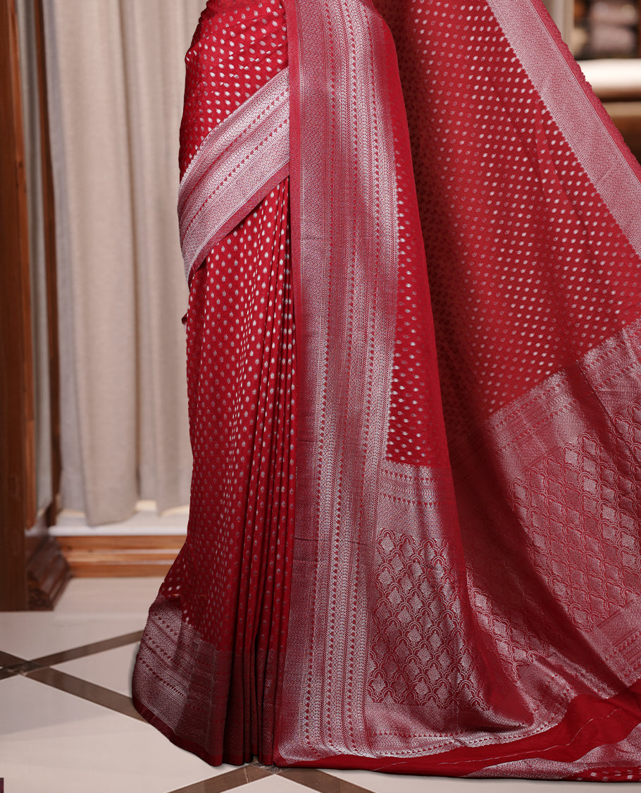 Maroon colour Banarasi silk saree featuring intricate zari weaving and a soft silk texture, Adorned with silver motifs on the body, complemented by a rich Banarasi border and pallu & Comes with a matching blouse.
