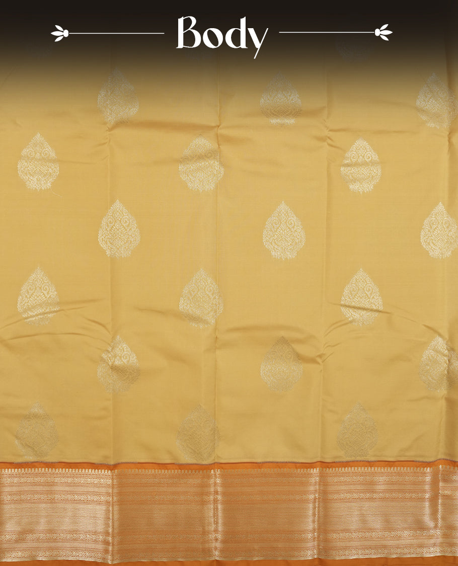 Muted yellow colour semi soft silk saree featuring a gold zari motifs on body, complemented by contrast mustard colour with gold traditional pallu & border and a matching blouse piece.