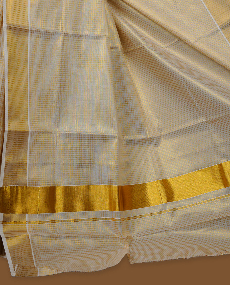 Off-white colour tissue Kerala saree with a subtle gold-toned checkered body, finished with a classic gold kasavu border along the edges and pallu, paired with a matching blouse.
