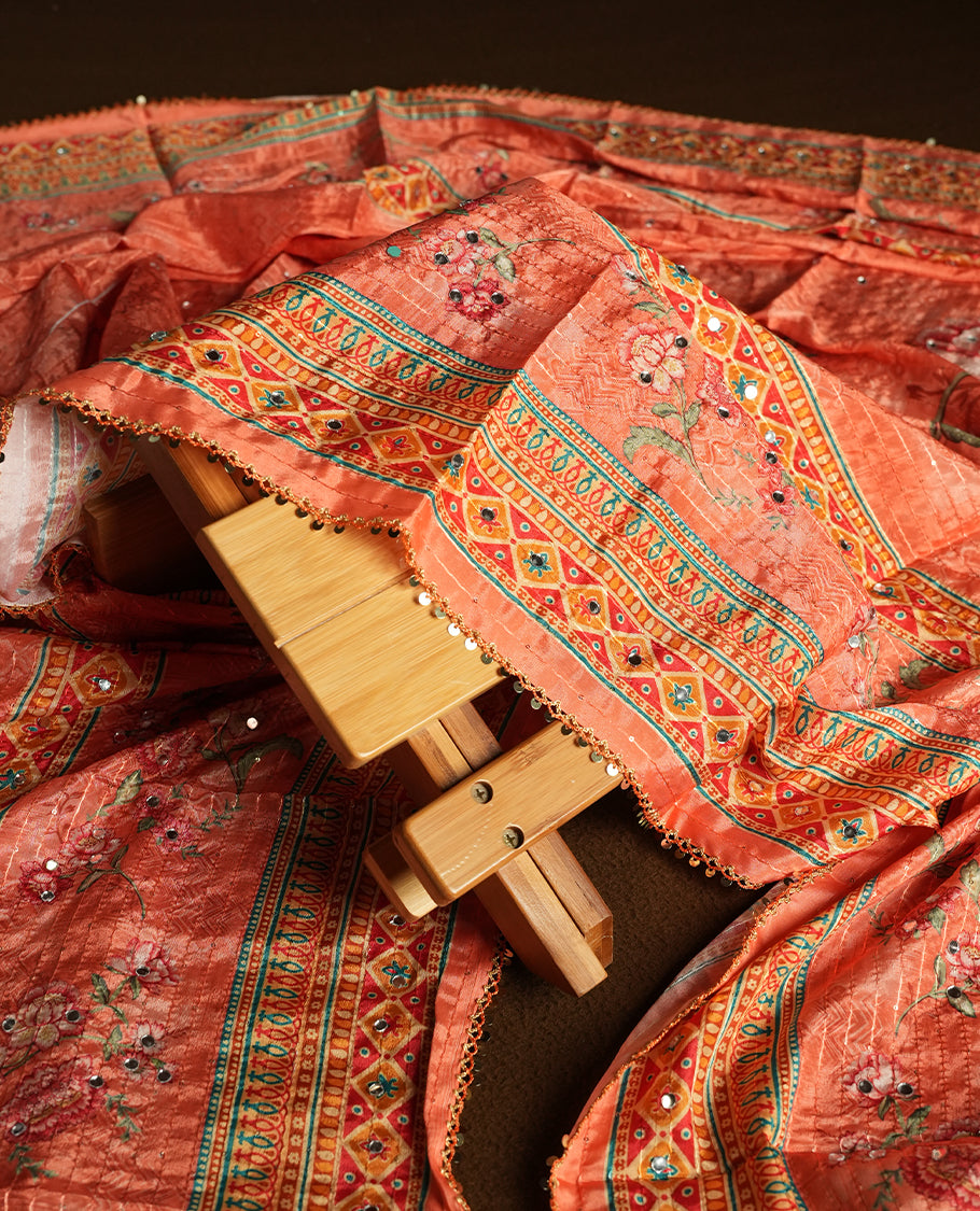 White colour churidhar material featuring Mirror and thread embroidery, foral print pattern on the contrast Orange colour front panel, floral digital printed dupatta with elegant border, and matching plain bottom