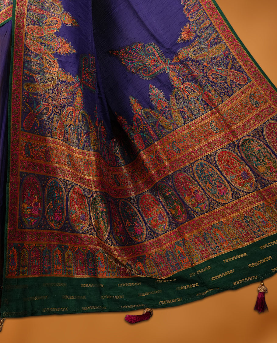 Indigo colour Pashmina silk saree densely woven with intricate multicolour floral and architectural motifs across the body, framed by an opulent arabesque border and grand storytelling pallu, paired with a matching black woven border blouse piece