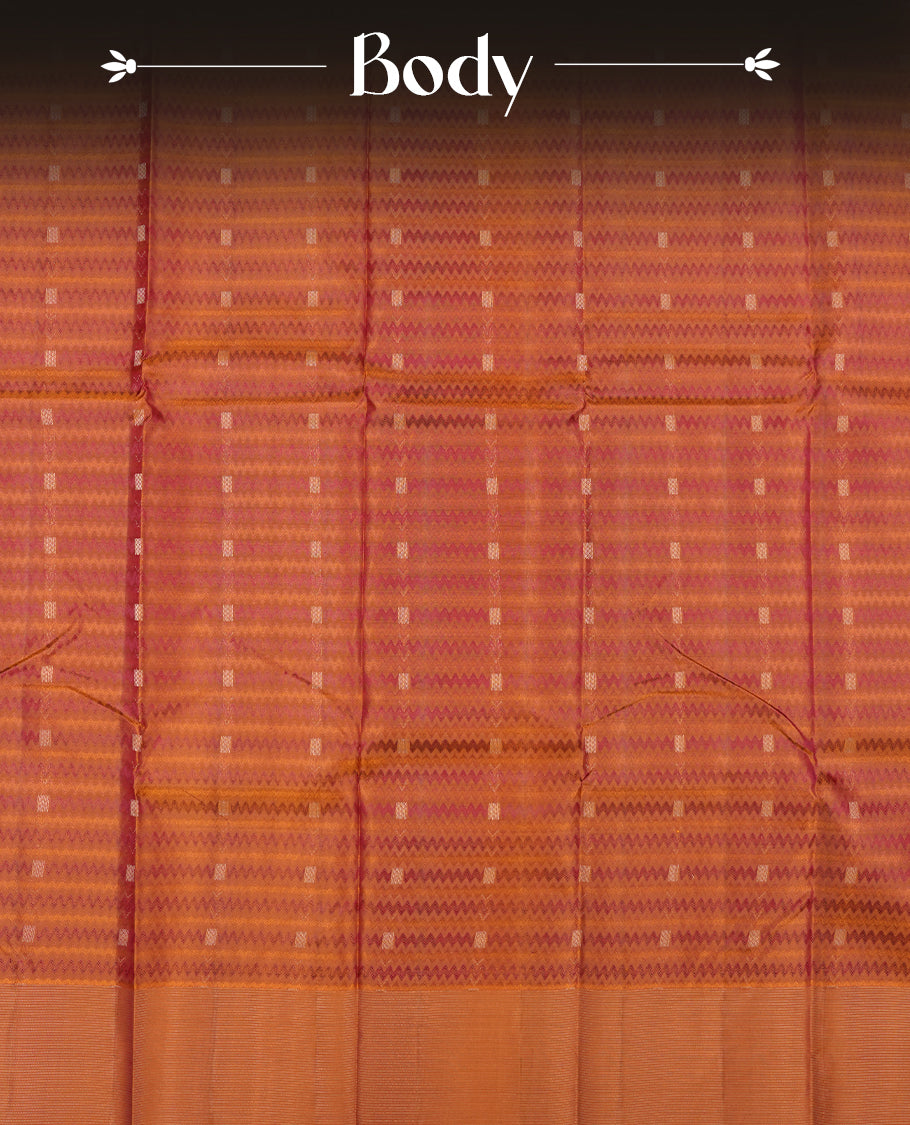 Burnt orange colour Vasundhara silk saree adorned with all-over purple zigzag motifs on the body, complemented by a self colour with gold line pattern border and paired with a matching blouse piece.