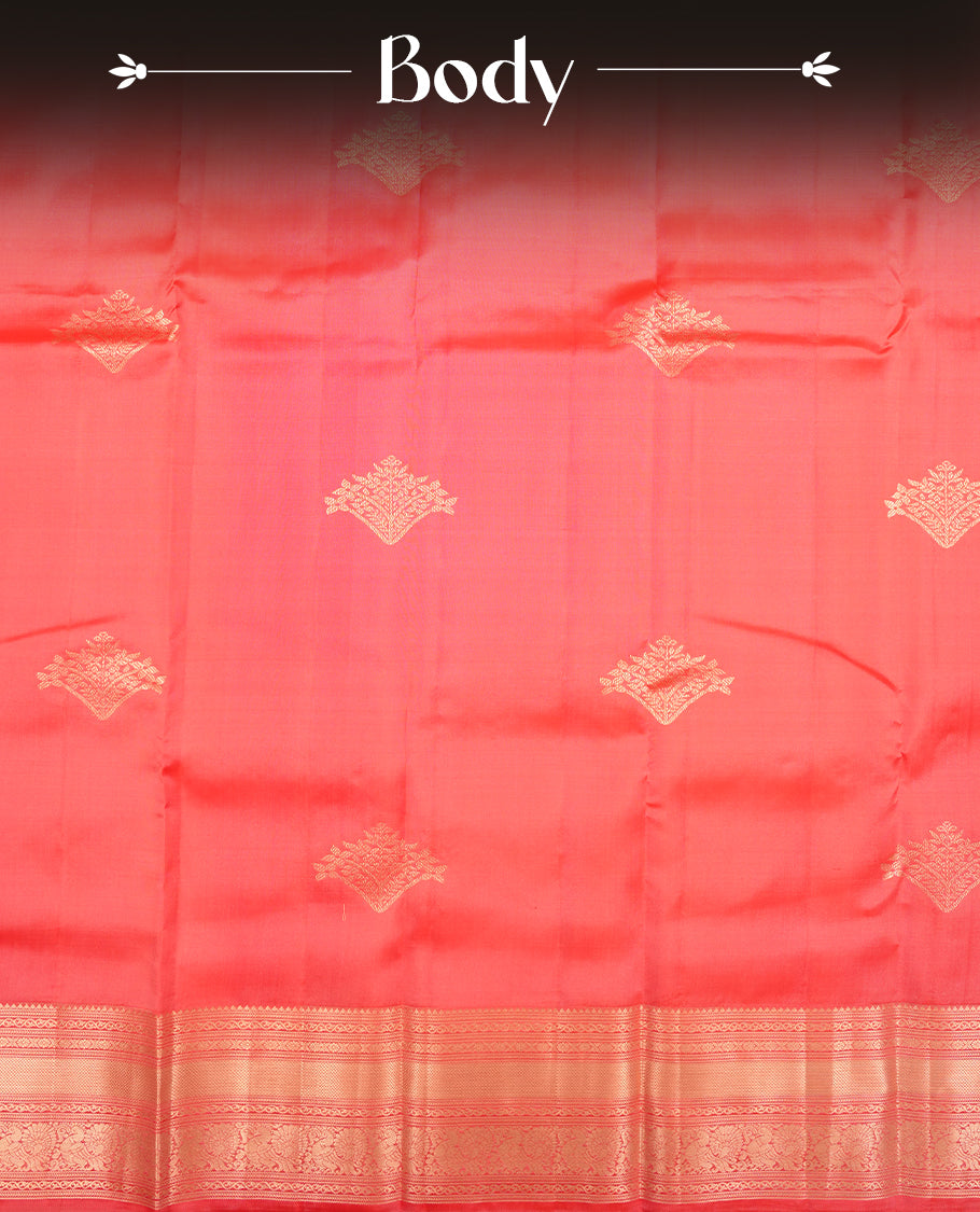 Reddish peach colour Vasundhara silk saree featuring Gold zari motifs across the body, finished with a self‑coloured traditional border and a coordinating blouse.