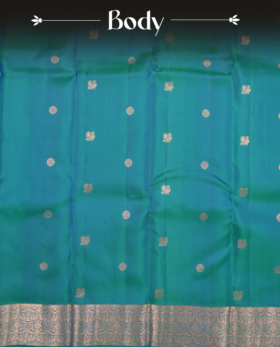 Peacock green colour Vasundhara silk saree adorned with all-over gold chakkaram& mayil motifs on the body, complemented by a self colour with rose gold traditional border and paired with a matching blouse piece.