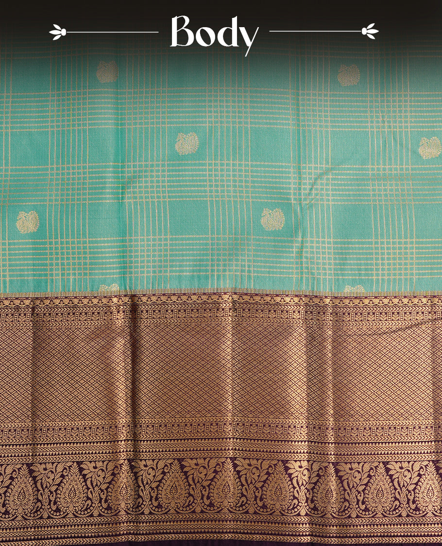 Light aqua colour semi wedding saree featuring gold zari motif on check pattern on body, complemented by contrast purple with traditional border, paired with matching blouse piece.