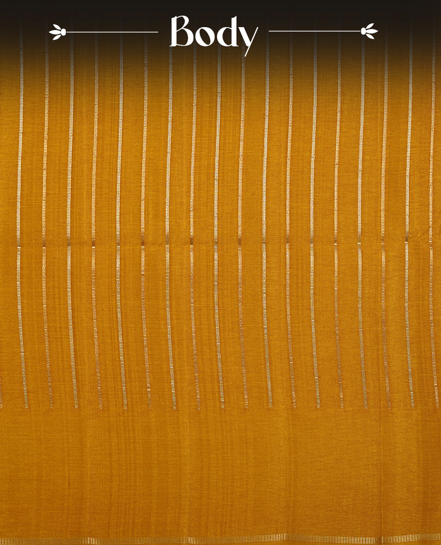 Mustard colour semi tussar silk saree highlights gold and silver zari stripes across body, border, pallu and paired with matching blouse piece.