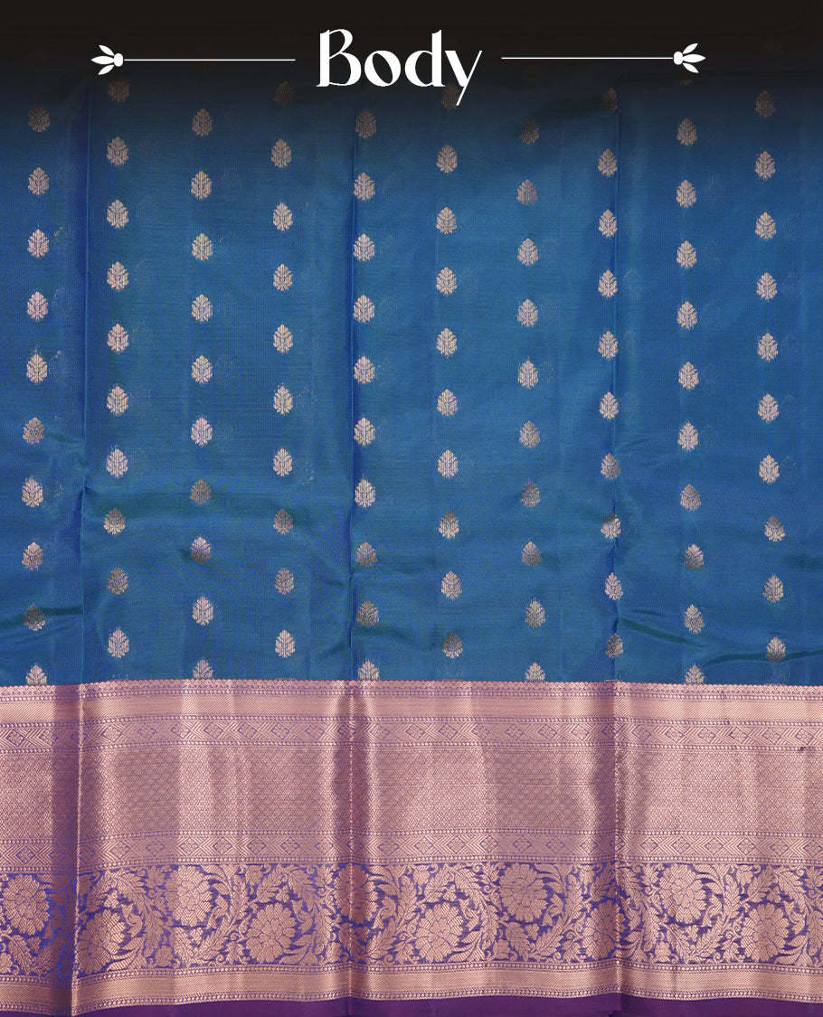 Peacock colour Soft silk saree featuring gold zari floral motifs on the body, complemented by a contrast Indigo traditional zari floral kodi border and pallu, paired with a matching blouse piece.