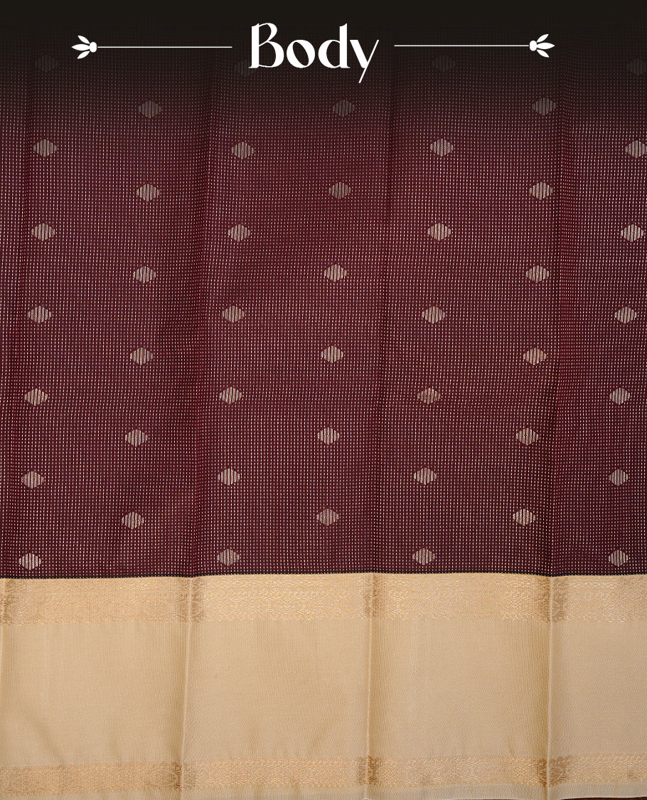 Chocolate brown coloured soft silk saree featuring gold zari stripes and motifs across the body, enhanced with a contrast Cream border and pallu, paired with a matching contrast blouse piece.