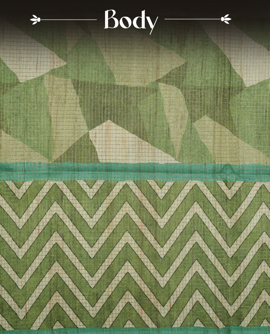 Green colour semi tussar silk saree featuring zigzag print and zari check pattern across body, self colour border with geometric pattern and pallu, paired with matching blouse piece.