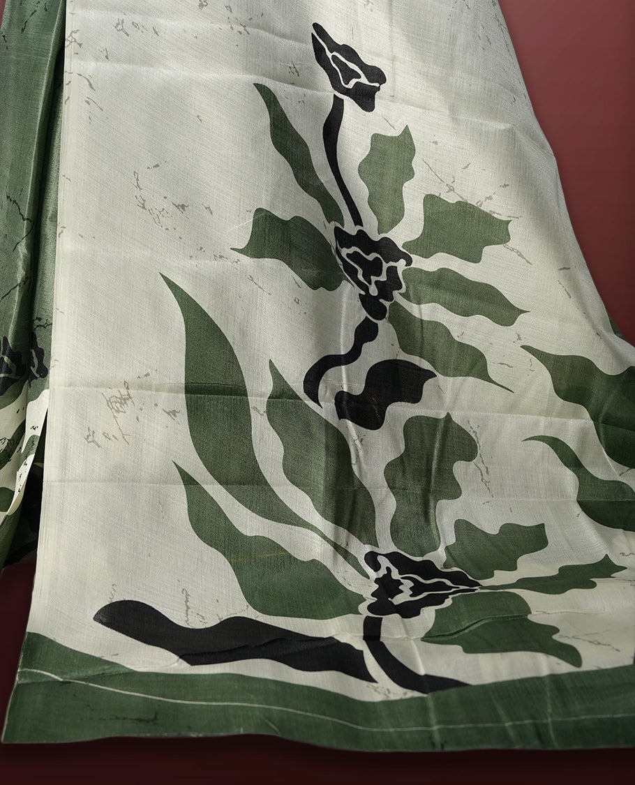 Olive green and off white colour saree with bold black floral prints enhancing its modern charm & Crafted from soft, lightweight fabric for elegant draping, this saree comes paired with a matching blouse piece.