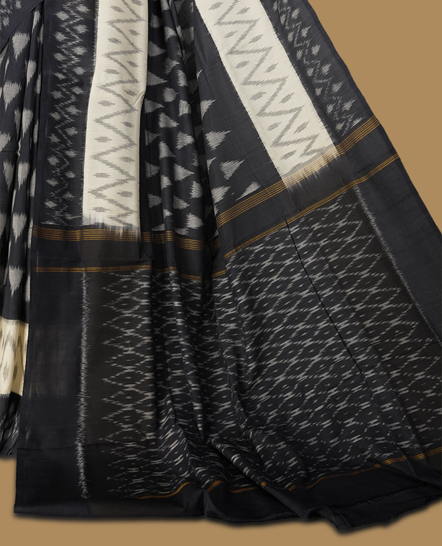 Black and Cream colour Ikkat Pochampally saree adorned with striking grey colour geometric motifs and a contrasting traditional border, The intricately woven pallu adds elegance, making it a timeless drape.