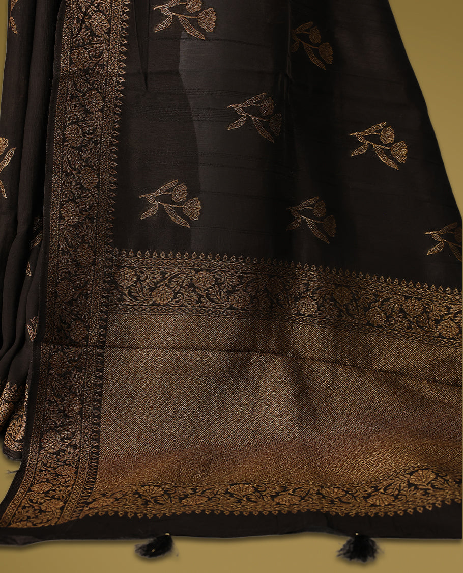 Black semi Banaras tussar saree adorned with golden floral motifs along the border and scattered designs across the body, finished with a rich golden zari pallu, paired with a matching blouse.
