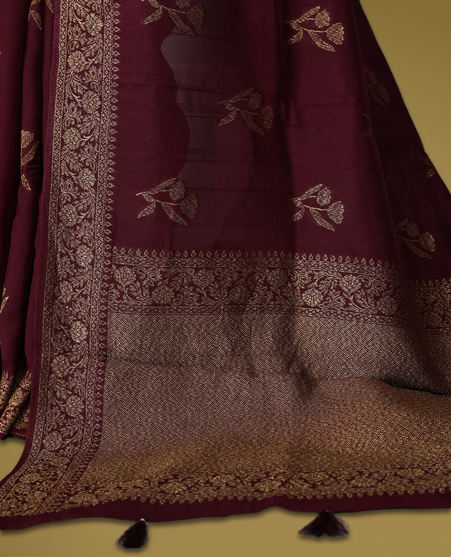 Dark coffee brown colour semi Banaras tussar saree adorned with golden floral motifs along the border and scattered designs across the body, finished with a rich golden zari pallu, paired with a matching blouse.