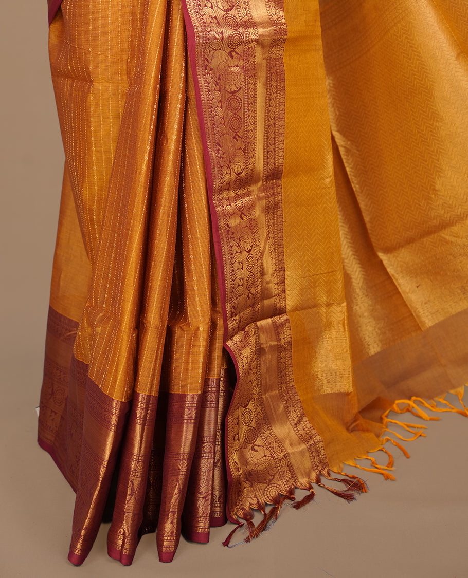 Mustard colour chettinad saree featuring gold zari stripes on body, complemented by contrast Maroon colour with traditional border, paired with matching blouse piece.