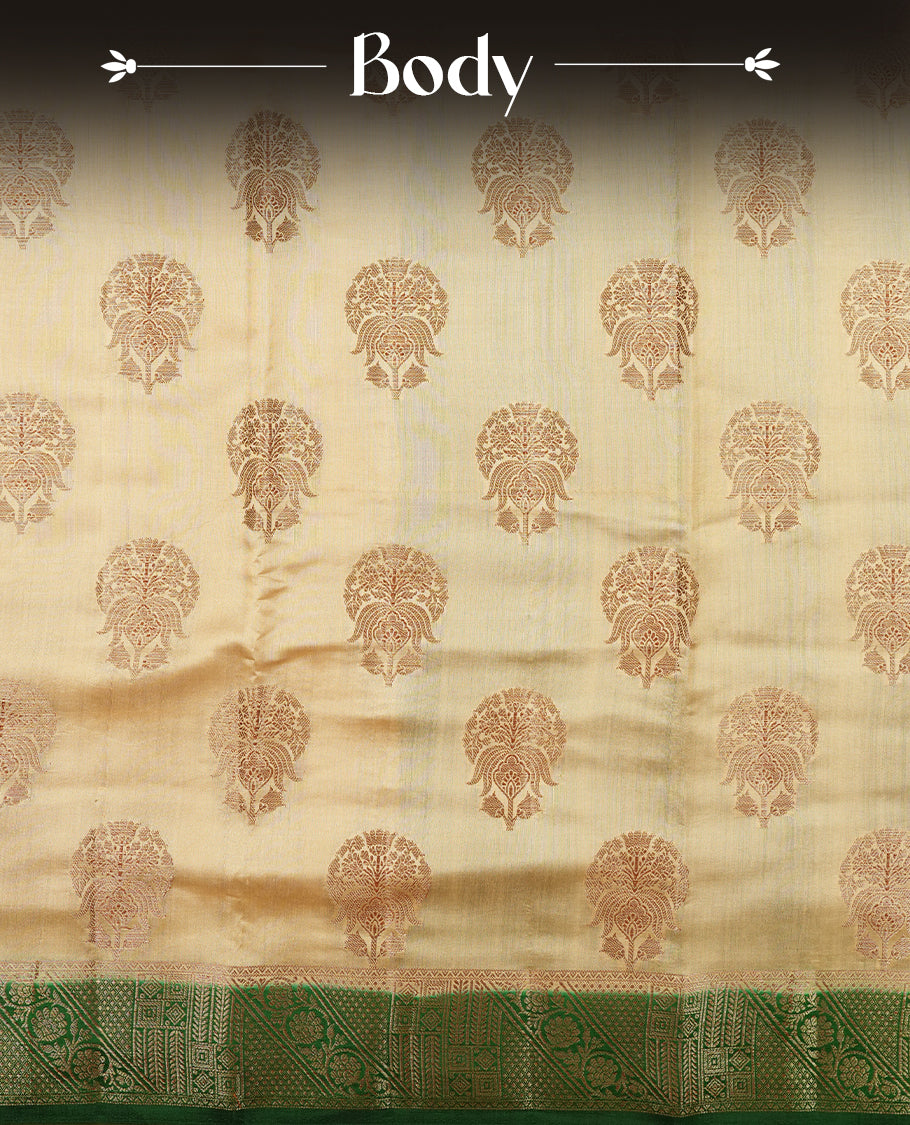 Cream beige Banaras soft silk saree with gold zari oval motifs on body, with contrast green colour floral pattern on pallu, border, and Matching blouse.