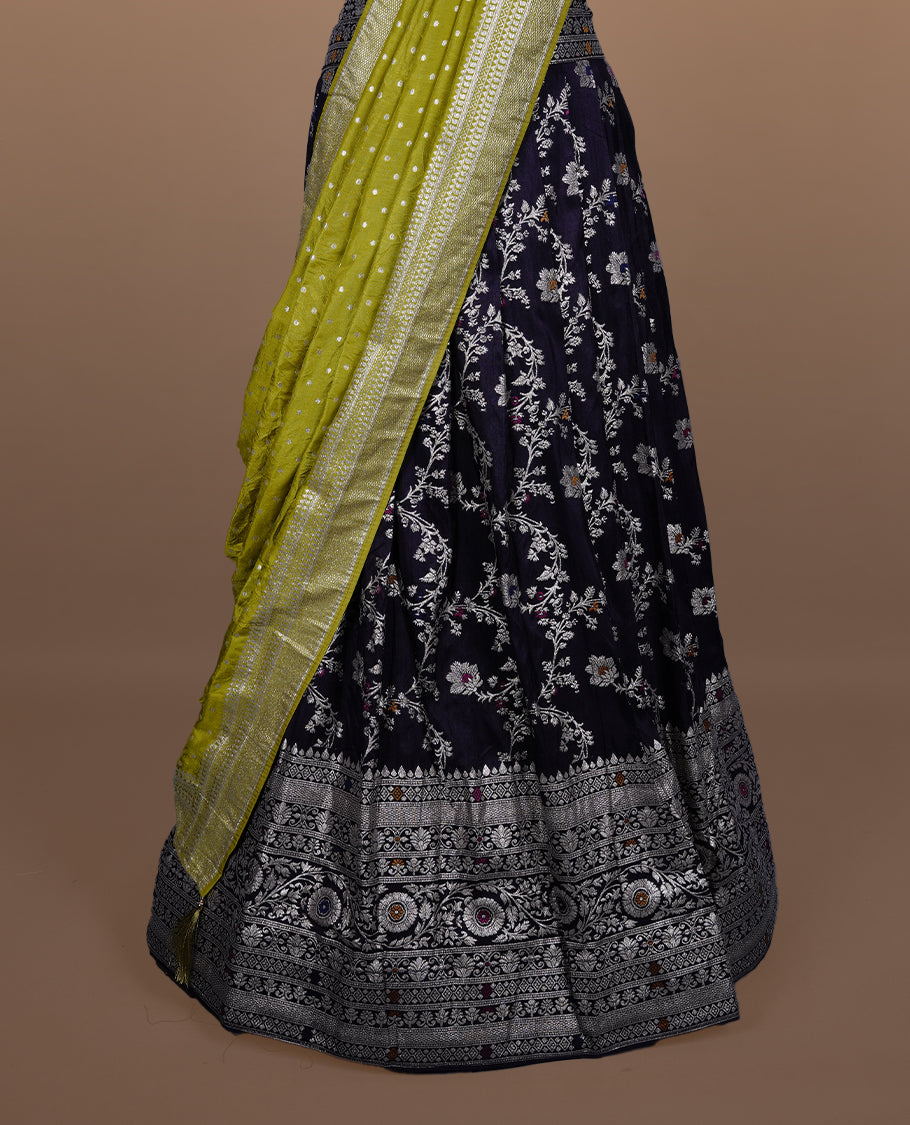 Deep purple colour semi banaras semi stitched dhavani set featuring gold zari floral kodi motifs and traditional border, unstitched matching blouse piece and contrast Olive colour Duptta with gold zari border.