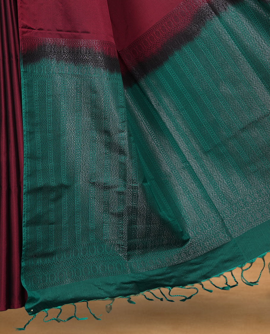 Maroon colour soft silk saree featuring Antique zari motifs on body with Highlighting contrast green colour pallu and paired with matching blouse piece.