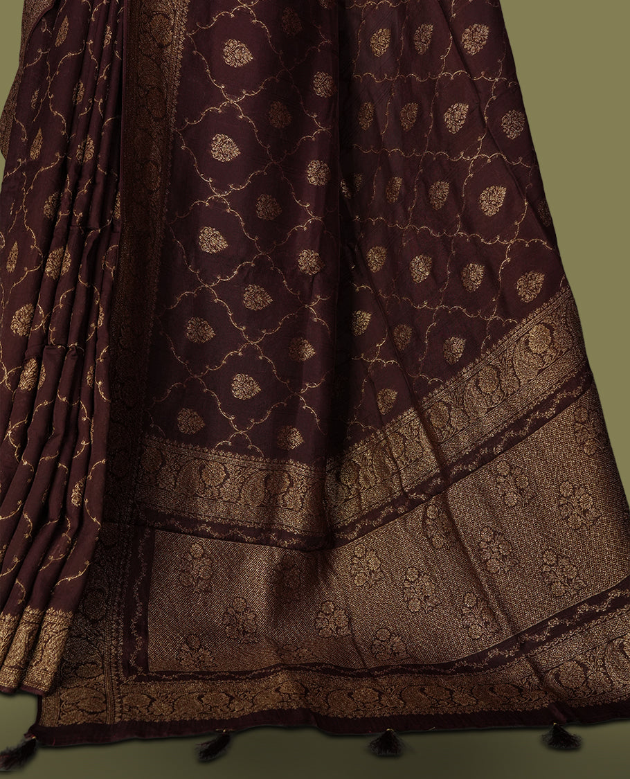 Coffee brown colour semi Banarasi Tussar Georgette saree with gold zari motifs on the body, a grand woven golden pallu, and ornate zari border. Includes a matching blouse piece for a complete look.