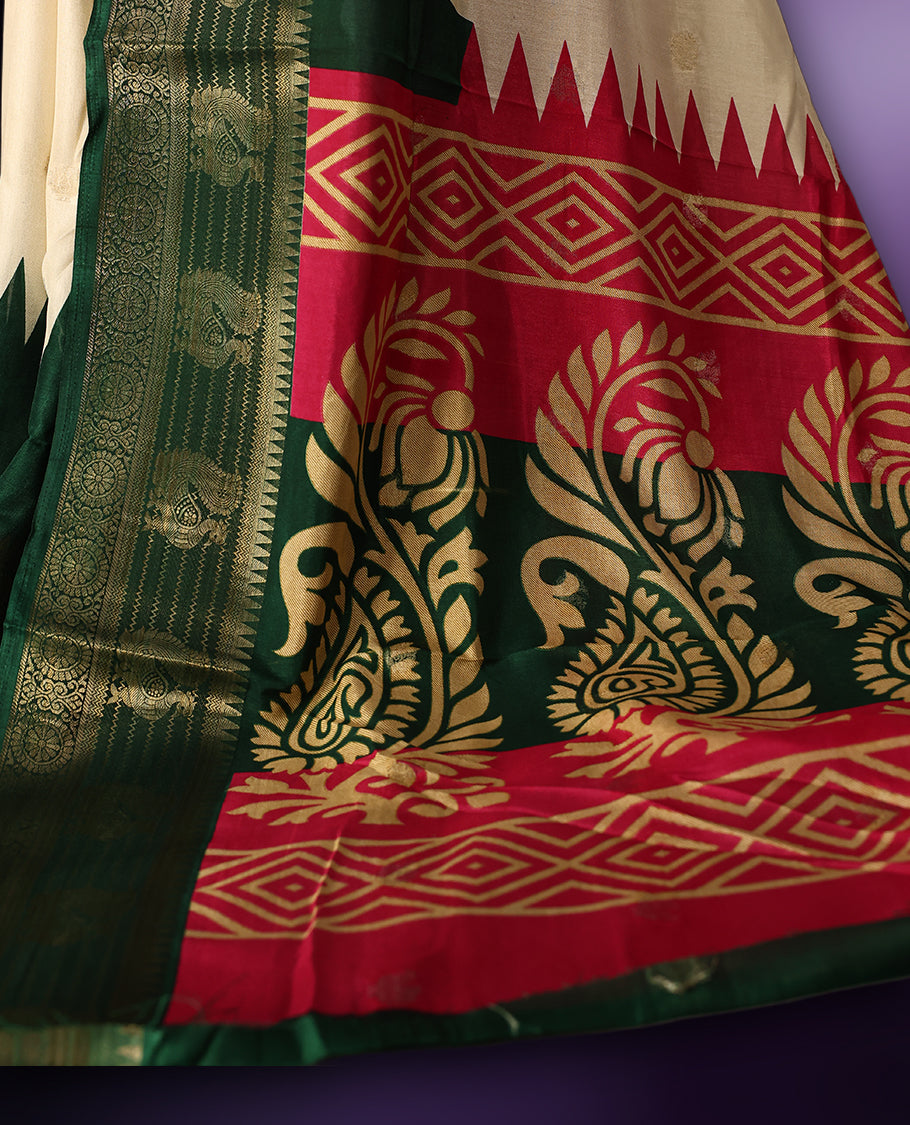 Off white colour saree with subtle golden buttas, highlighted by a vibrant pink pallu and rich green zari border adorned with intricate motifs, paired with a matching blouse.