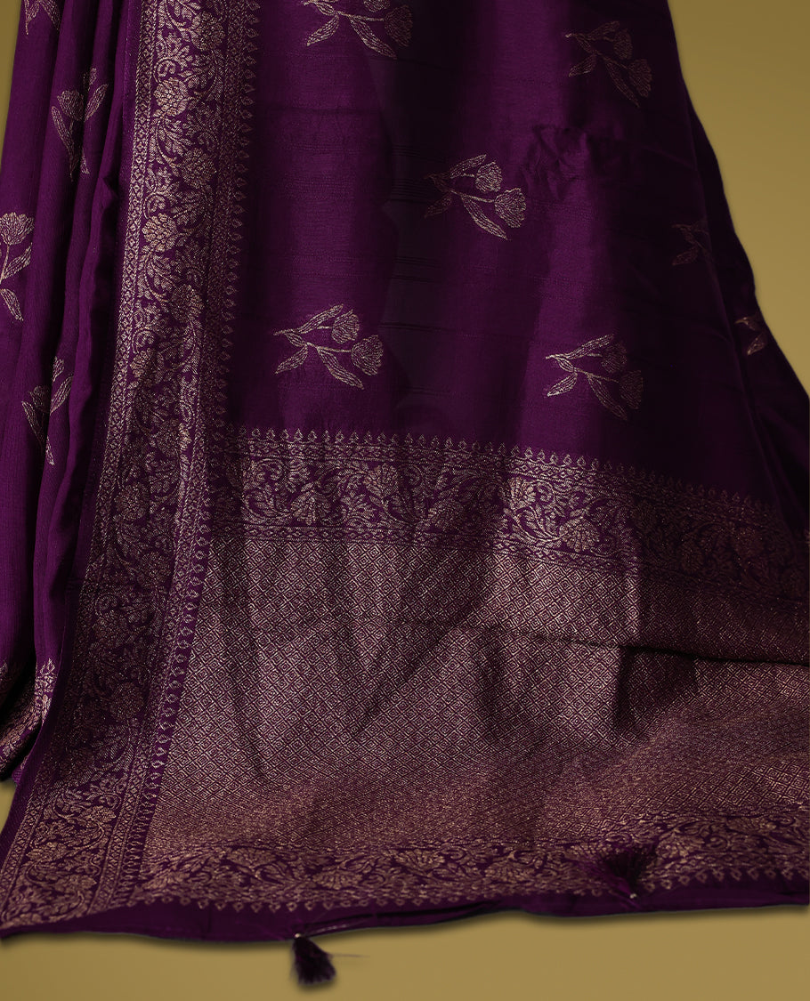 Wine colour semi Banaras tussar saree adorned with golden floral motifs along the border and scattered across the body, finished with a rich golden zari pallu, paired with a matching blouse.