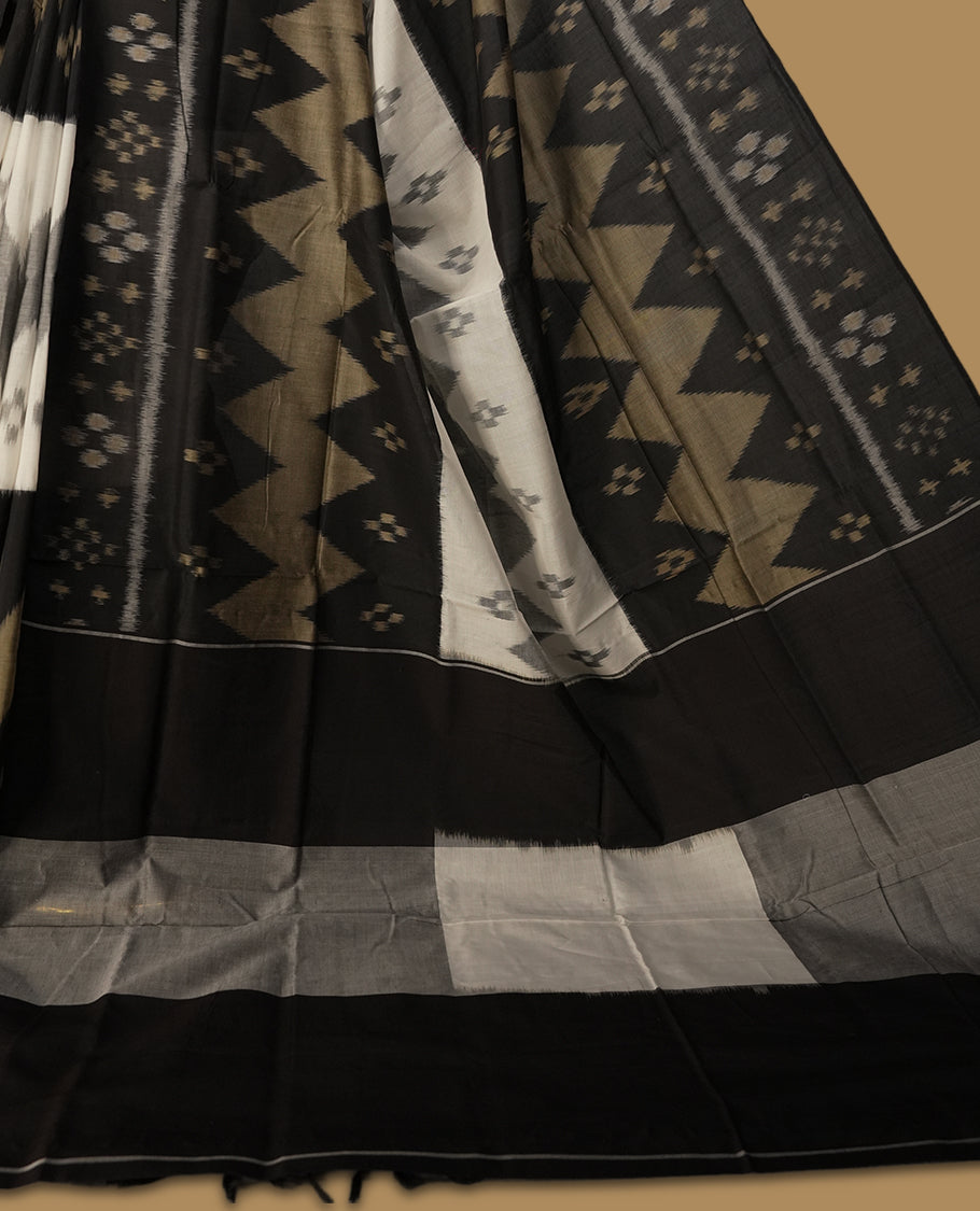 Black colour Ikkat Pochampally saree featuring bold geometric motifs in beige, white, and grey with a striking contrast border, beautifully blending tradition with elegance, Comes with matching blouse.