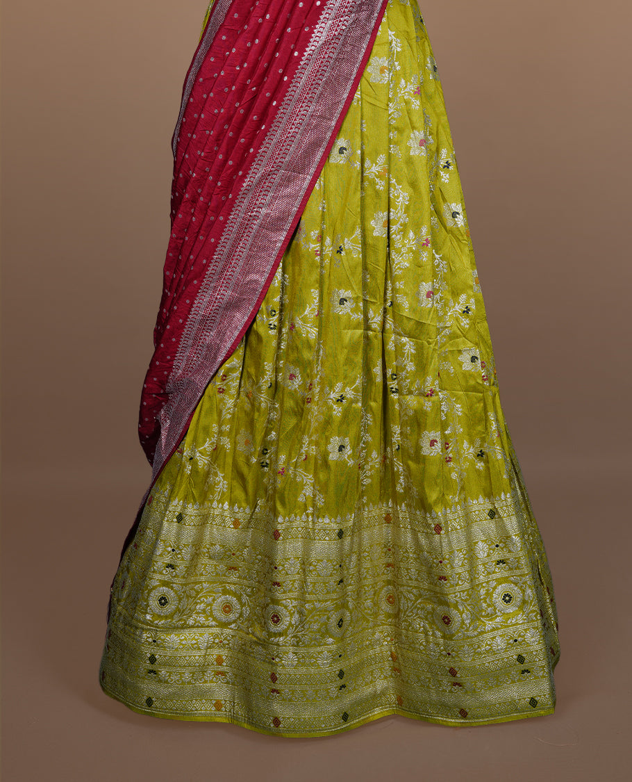 Olive colour semi banaras semi stitched dhavani set featuring silver & multicolour zari motifs and traditional border, unstitched matching blouse piece and contrast red colour Duptta with silver zari border.