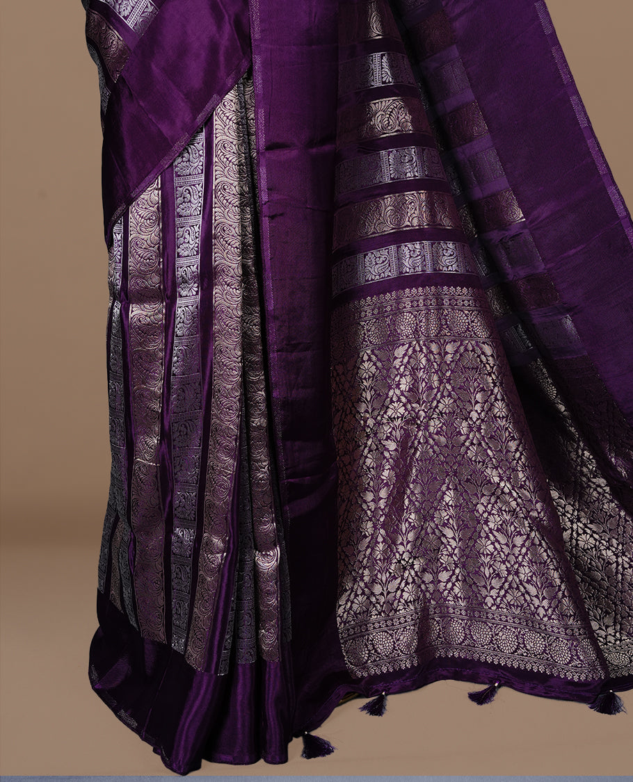 Purple colour banaras crepe saree featuring gold & silver zari design stripes on body, complemented by self colour border, paired with matching blouse piece.