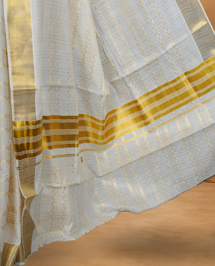 Off white Cotton Kerala saree featuring a subtle zari patterned body, complemented by a classic golden zari border and traditional pallu, paired with a matching blouse.