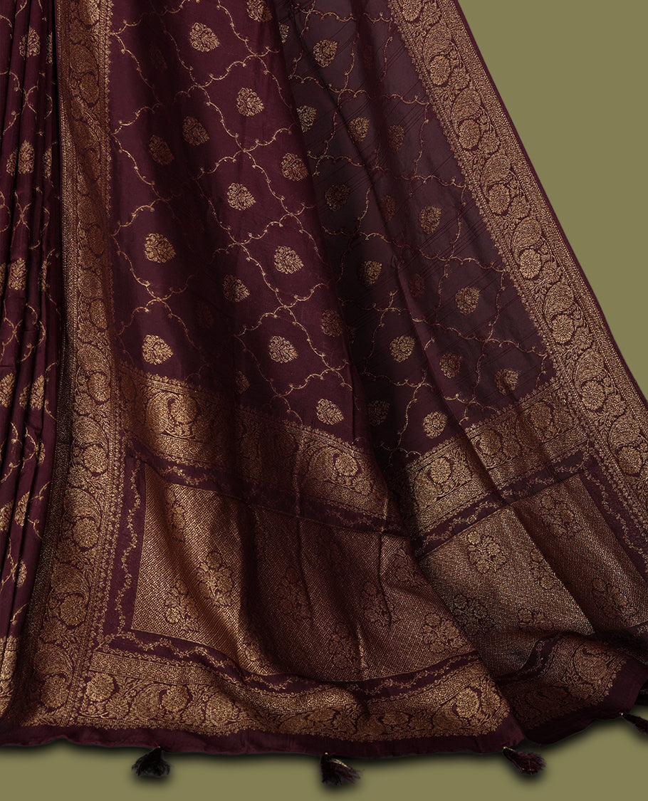 Dark maroon colour semi Banarasi Tussar Georgette saree with gold zari motifs on the body, a grand woven golden pallu, and ornate zari border. Includes a matching blouse piece for a complete look.