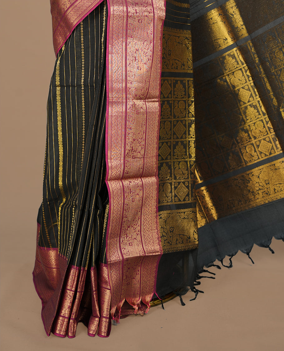 Black colour chettinad saree featuring gold zari stripes on body, complemented by contrast magenta colour with traditional border, paired with matching blouse piece.