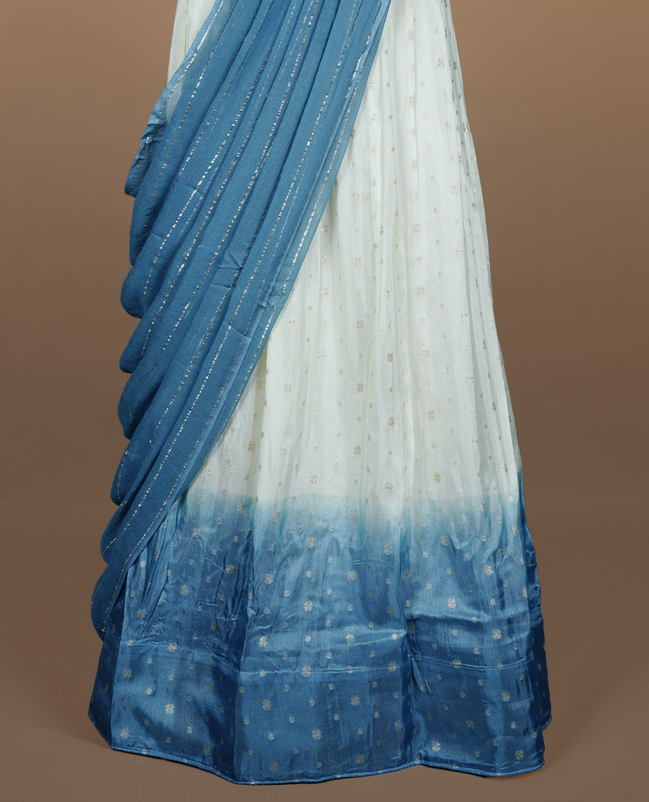 Off white semi banaras semi stitched dhavani set featuring gold zari motifs and contrast Bluecolour border, unstitched gold zari blouse piece and matching Duptta with gold zari stripes.