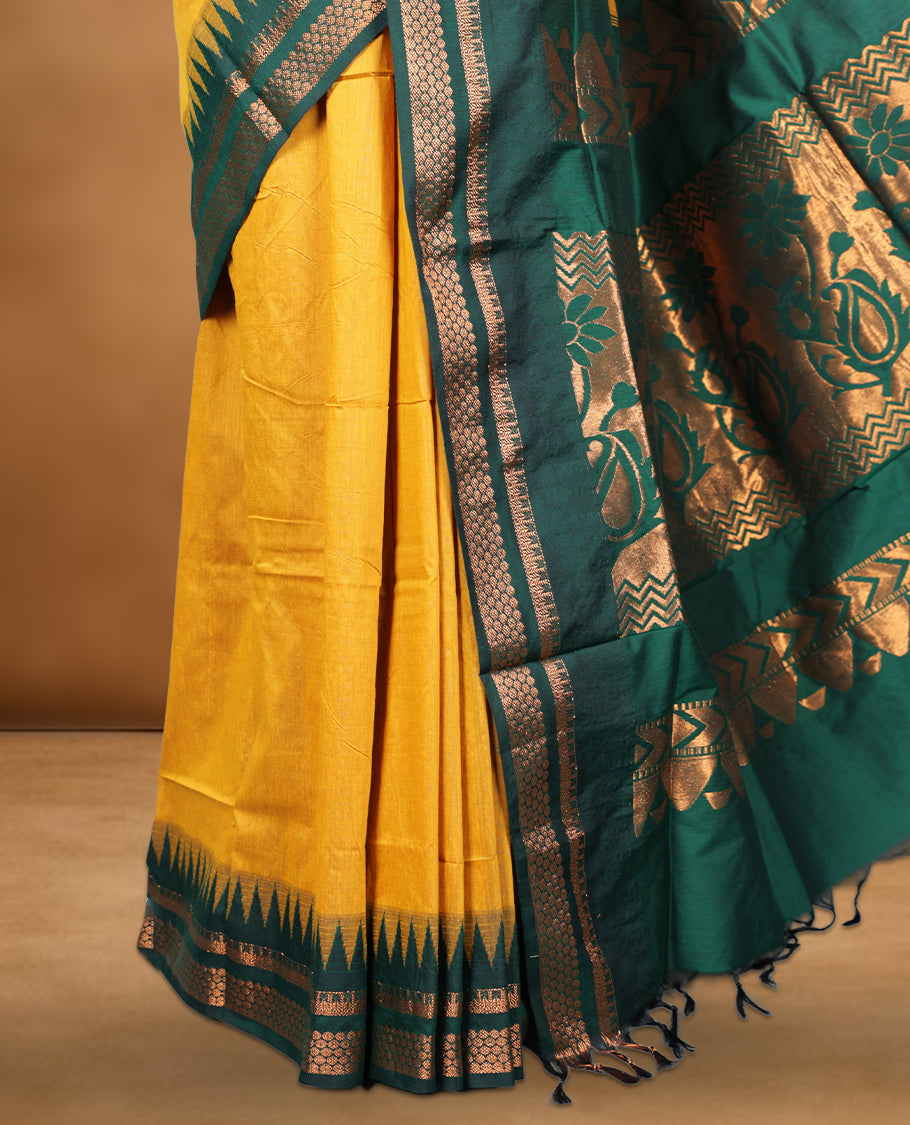 Mustard colour kalyani cotton saree featuring Antique zari motifs on body, contrast green colour border with geometric antique zari pattern, paired with matching blouse piece.