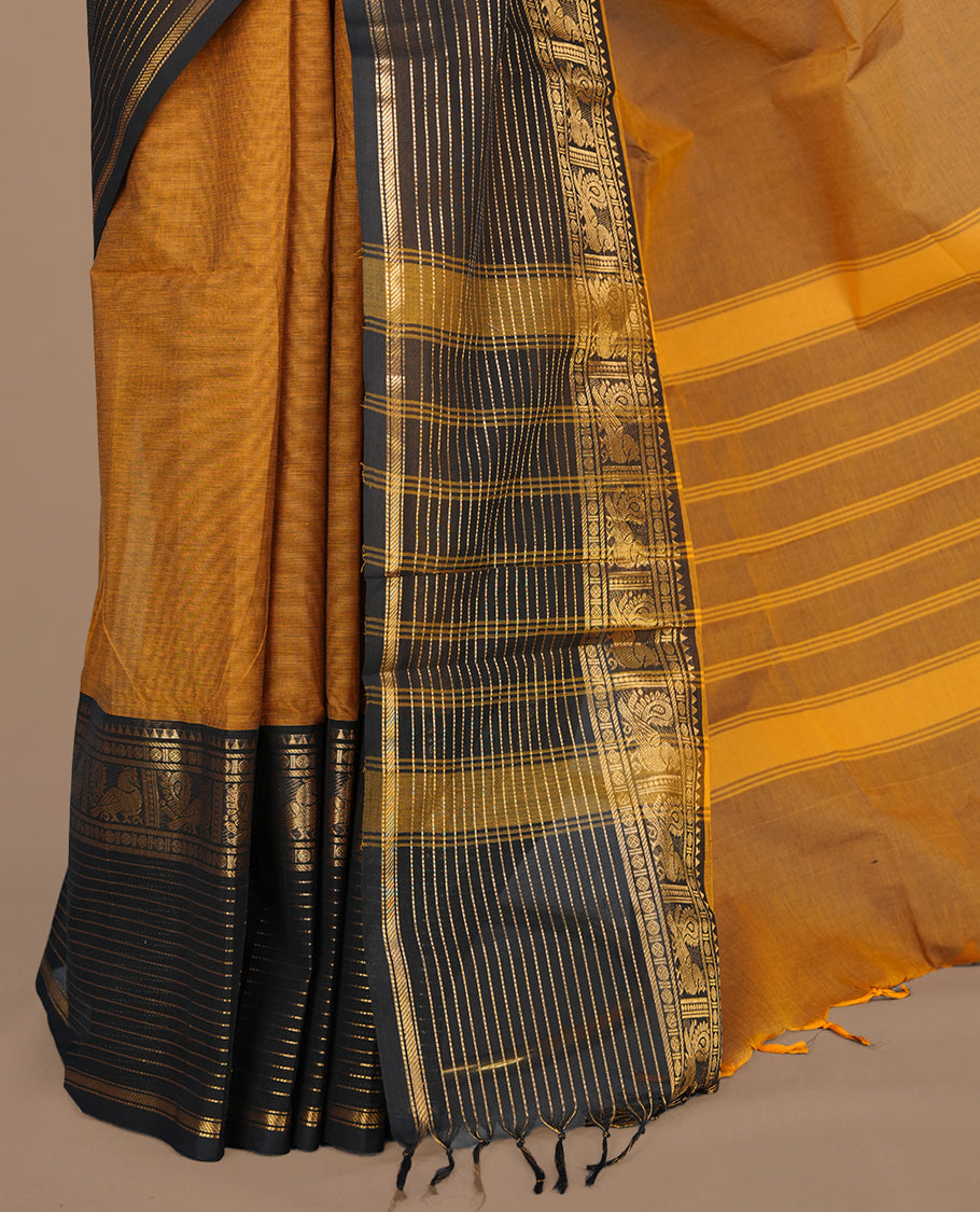 Mustard colour chettinad cotton saree featuring elegant plain body, complemented by contrast black colour with traditional border, paired with matching blouse piece.
