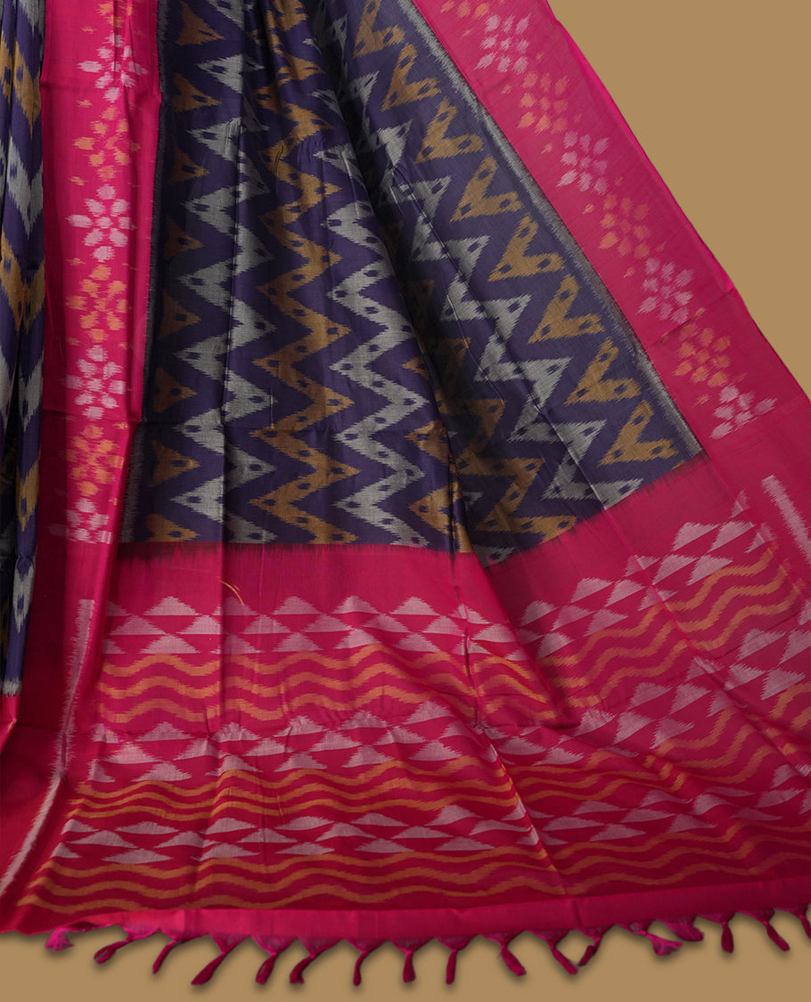 Navy blue colour Ikkat Pochampally saree featuring a vibrant magenta pink border and pallu adorned with traditional ikat motifs in shades of beige & grey, bringing a perfect blend of heritage and modern charm, Comes with matching blouse.