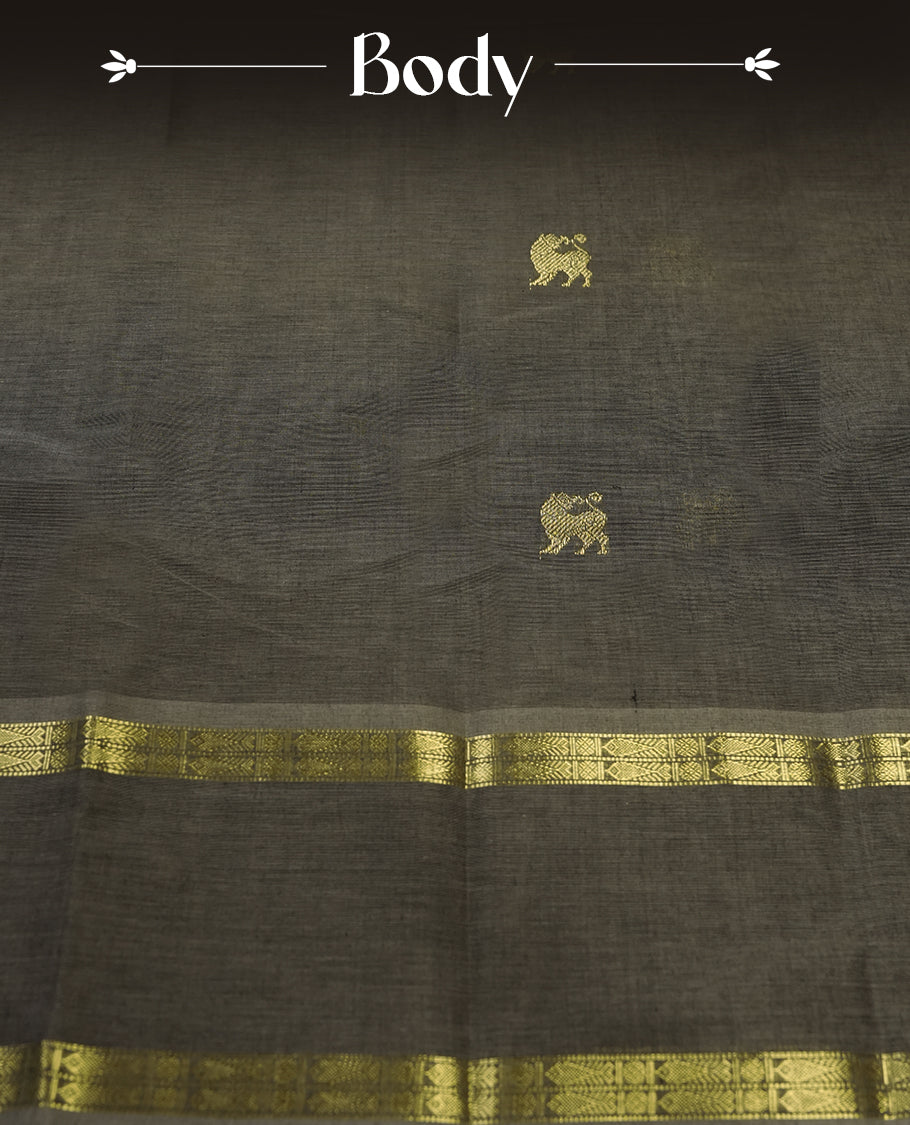 Grey colour Pure Kanchi cotton saree adorned with subtle golden buttas all over, highlighted by a rich zari woven border with traditional motifs & Includes a matching blouse piece for a complete look.