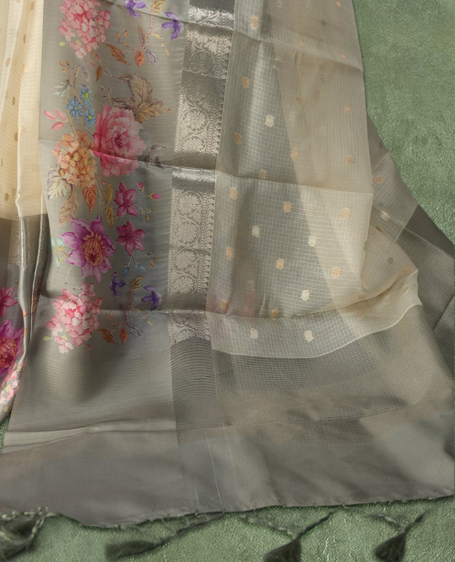Ivory colour Kotta Tussar Silk saree features a vibrant digital floral print with small gold zari motifs on the body, and elegant blue colour banarasi border & Paired with a matching blouse,blending modern design with traditional elegance.
